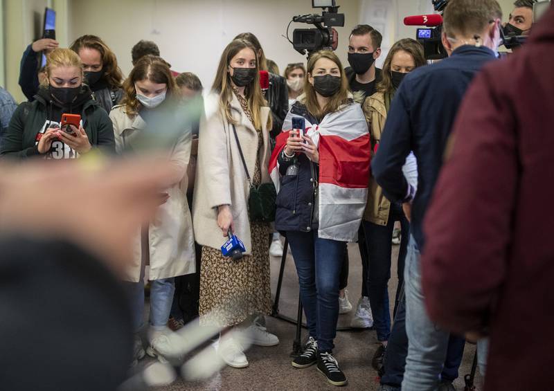 В воскресенье вечером в аэропорту Вильнюса журналисты и демократические активисты ждут пассажиров перенаправленного рейса в Минск, где был задержан противник Лукашенко. (Mindaugas Kulbis/AP)