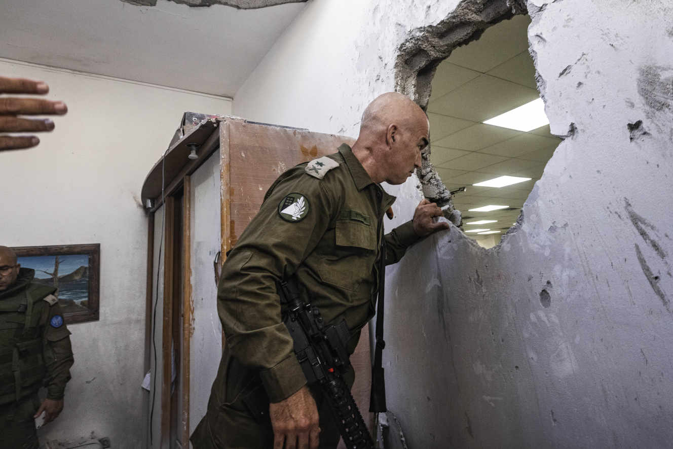 Офицер израильской армии осматривает поврежденную синагогу после попадания в нее ракеты, выпущенной из сектора Газа, в Ашкелоне, Израиль, в воскресенье, 16 мая 2021 года. TSAFRIR ABAYOV / AP